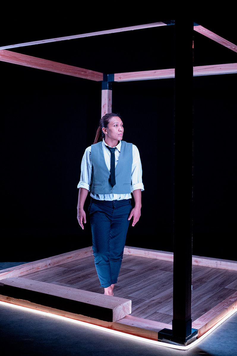 photo de soria qui danse dans une structure en bois sur un fond bleu.